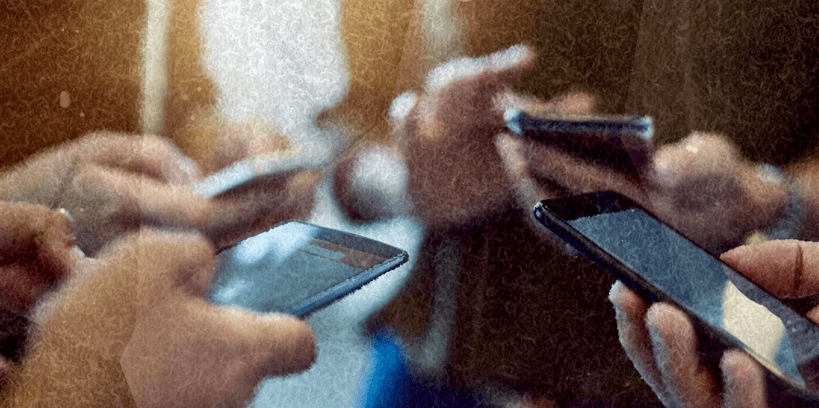 A circle of hands all holding phones — the distraction Bloom blocks