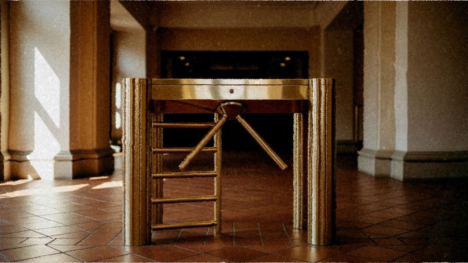 A brass turnstile gate in a warm-lit entrance hall.
